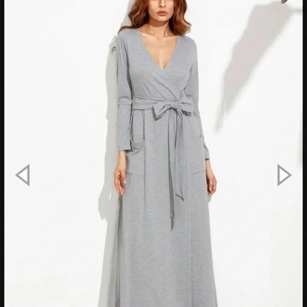 A long gray dress with a tie on the middle and a long sleeve